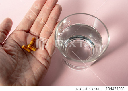 Capsule in palm and water (taking the medicine) Capsule in palm and water (taking the medicine) 134873631
