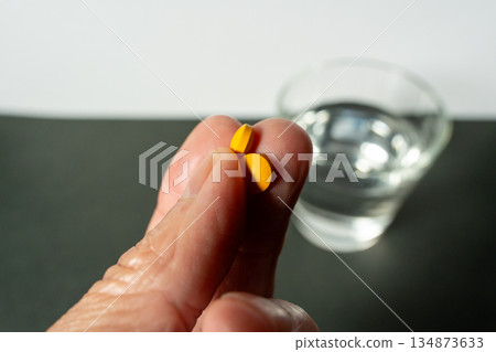 A pill on the fingertip, water in the back (image of taking medicine) Tag idea 134873633