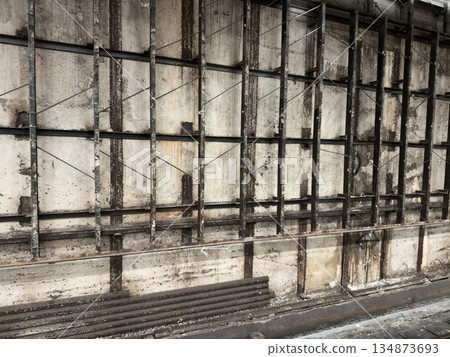 Welded metal frame on concrete wall during renovation. Cladding work at construction site. Double wall with frame on main wall and future tiles on metal frame Welded metal frame on concrete wall during renovation. Cladding work at construction site. Double wall with frame on main wall and future tiles on metal frame 134873693