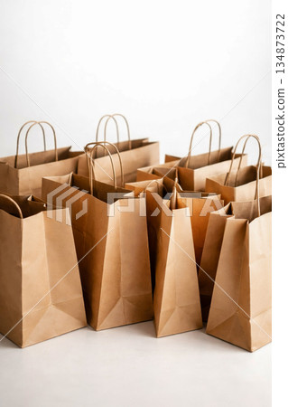 Many paper shopping bags arranged together on white background Many paper shopping bags arranged together on white background 134873722