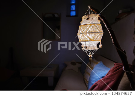 Warm hanging lantern illuminates a cozy interior with beaded, handcrafted detail for home decor 134874637