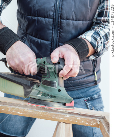 Carpenter at work, restoring an old wooden window. Carpentry. 134875229
