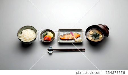 Minimalist flat lay, Japanese minimalist. a traditional breakfast set a small grilled salmon, a bowl of miso soup, a portion of rice, and pickled vegetables Minimalist flat lay, Japanese minimalist. a traditional breakfast set a small grilled salmon, a bowl of miso soup, a portion of rice, and pickled vegetables 134875556