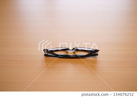eyeglasses on wooden table 134876252