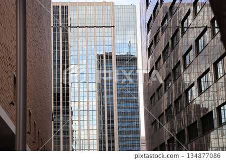 Cityscape of an urban area with blue sky reflected in the windows of a building and skyscrapers Cityscape of an urban area with blue sky reflected in the windows of a building and skyscrapers 134877086