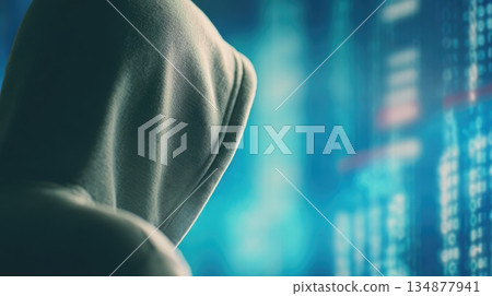 Anonymous Hacker in Hoodie Using Computer Code in Dark Cybersecurity Concept 134877941