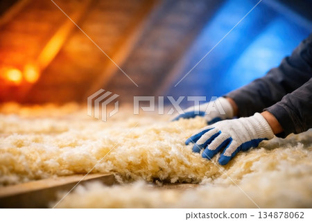 Installing Mineral Wool Insulation with Protective Gloves in Industrial Environment Installing Mineral Wool Insulation with Protective Gloves in Industrial Environment 134878062