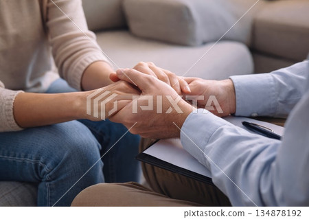 Therapist Holding Patient Hands Offering Support During Counseling Session 134878192