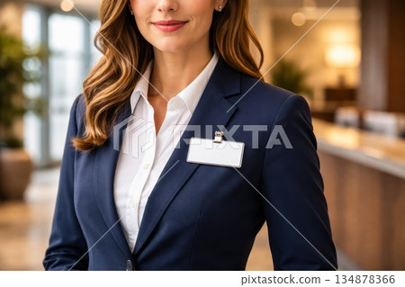 Professional Businesswoman Wearing Name Badge in Modern Office Lobby Professional Businesswoman Wearing Name Badge in Modern Office Lobby 134878366