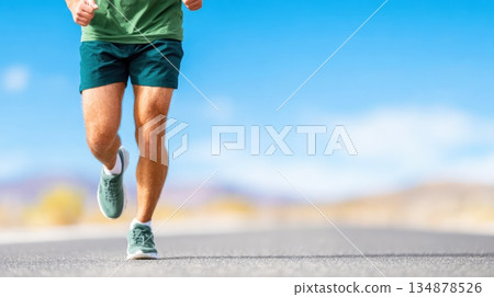 Male Runner Legs Jogging on Open Road on Sunny Day 134878526