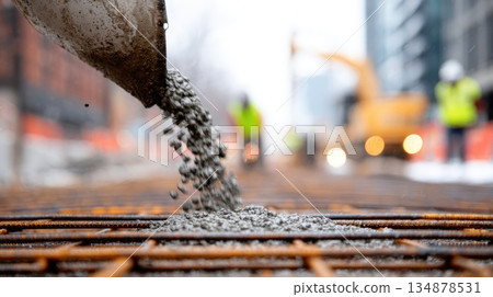 Pouring Concrete at Urban Construction Site with Workers in Background Pouring Concrete at Urban Construction Site with Workers in Background 134878531