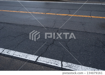 Cracks and lines in the road 134879161