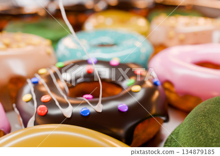 將白色奶油滴在擺放在托盤上的彩色甜甜圈上 134879185