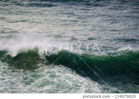 Powerful ocean waves crash and roll with white foam over deep blue-green water Powerful ocean waves crash and roll with white foam over deep blue-green water 134879820