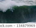 Majestic curling ocean wave with green lip and spray in a powerful seascape for stock use 134879969