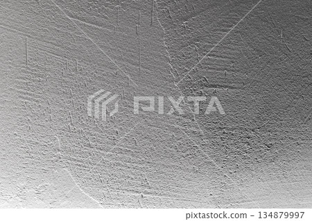 A neutral gray wall with a rich, rough texture and soft gradient 134879997