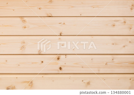 A wall panel of warm, light pine wood planks with natural grain and knots 134880001