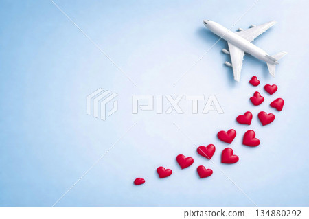 Airplane leaving trail of red hearts in sky as Valentine love travel romance and emotional connection concept 134880292