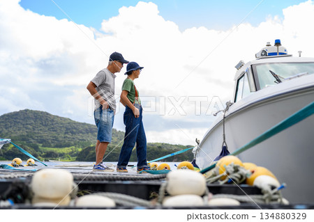 一對情侶在碼頭上觀賞船隻（照片由沖繩海濱度假村雅提供） 134880329