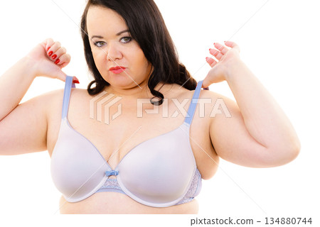 Big woman wearing lingerie holds bra strap Big woman wearing lingerie holds bra strap 134880744