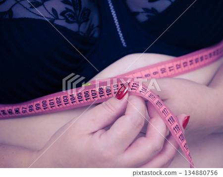 Woman measuring her chest under breasts 134880756