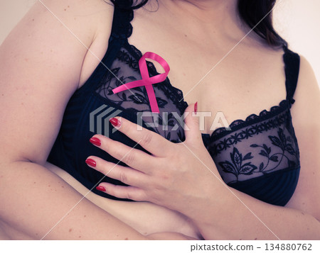 Woman chest in bra, pink cancer ribbon 134880762