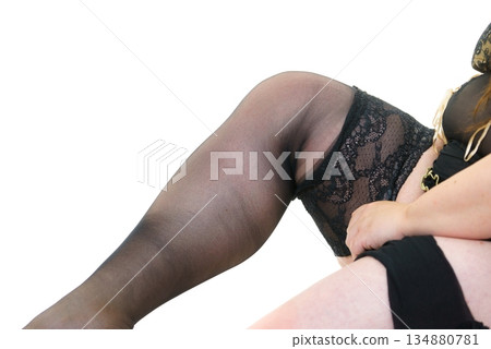 Woman plus size puts on black nylon stockings Woman plus size puts on black nylon stockings 134880781