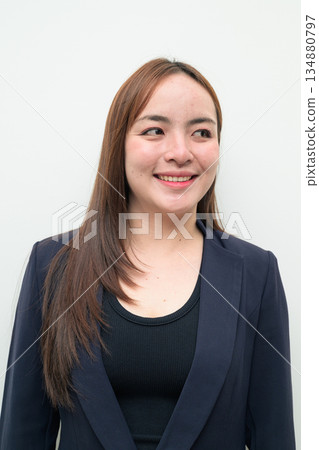 Portrait of a young happy Asian businesswoman against white background thinking 134880797