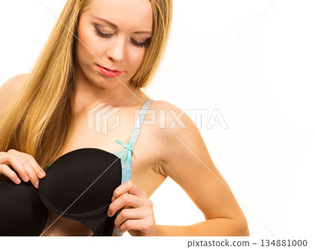 Woman trying on black bra Woman trying on black bra 134881000