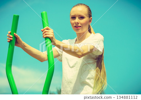 Girl exercise at outdoor gym area 134881112