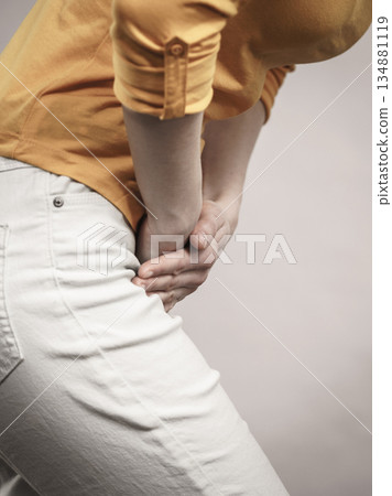 Woman with hands holding her crotch Woman with hands holding her crotch 134881119