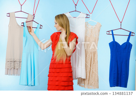 Woman choosing clothes in shop Woman choosing clothes in shop 134881137