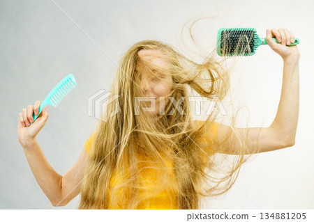 Girl blowing hair with comb brush 134881205