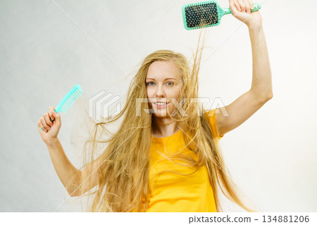 Girl blowing hair with comb brush 134881206
