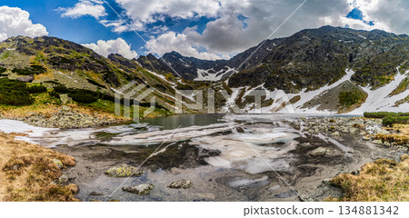 Panoramic view of a frozen glacial lake surrounded by snowy peaks in High Tatras Panoramic view of a frozen glacial lake surrounded by snowy peaks in High Tatras 134881342