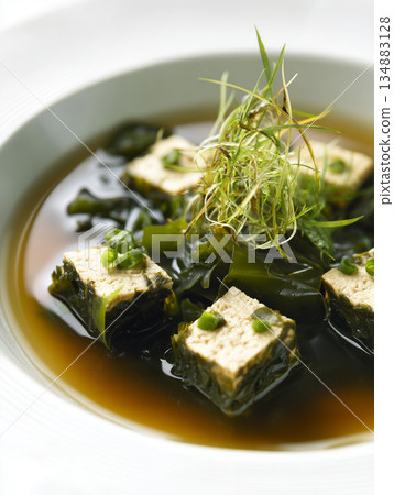 Gourmet Japanese Seaweed and Tofu Soup with Elegant Garnish in White Porcelain Bowl Gourmet Japanese Seaweed and Tofu Soup with Elegant Garnish in White Porcelain Bowl 134883128