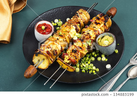 Delicious skewers with potatoes. 134883199