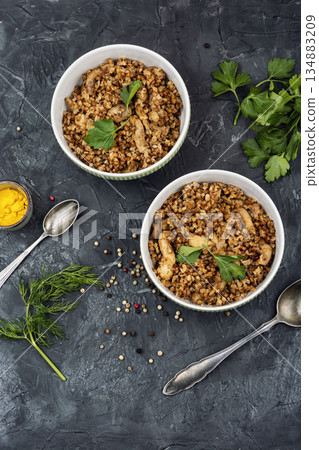 Cooked buckwheat porridge with meat stew. 134883209
