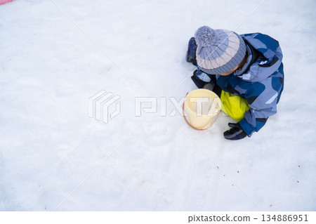 A child sitting on the snow A child sitting on the snow 134886951