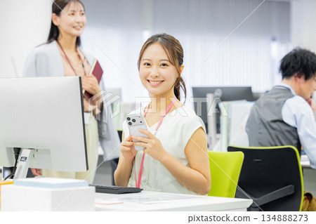 A woman operating a smartphone in the office A woman operating a smartphone in the office 134888273