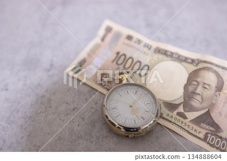 一張皺巴巴的10000日元鈔票和一塊懷錶－時間即金錢的意象。 134888604