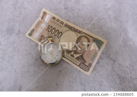 一張皺巴巴的10000日元鈔票和一塊懷錶－時間即金錢的意象。 134888605