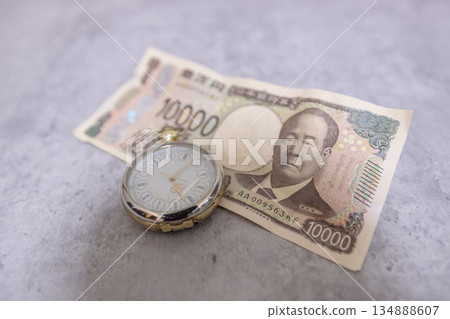 A wrinkled 10,000 yen bill and a pocket watch - the image of time being money 134888607