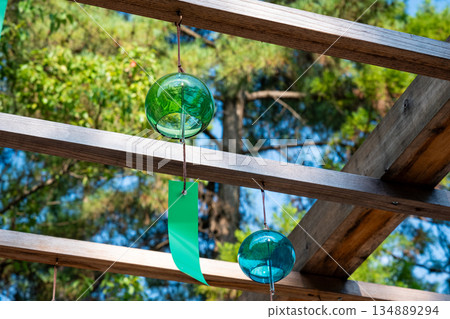 Green and blue wind chimes swaying in the blue sky Green and blue wind chimes swaying in the blue sky 134889294