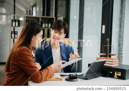 Business people compassionately holding hands and discussing contract papers with laptop and tabletat office 134889525
