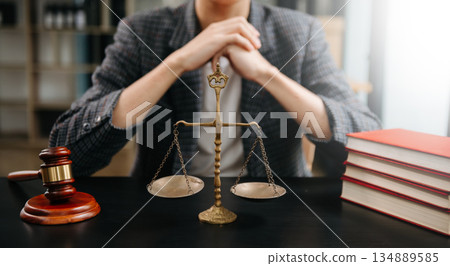 Male lawyer in the office with brass scale on wooden table. justice and law concept in morning light 134889585