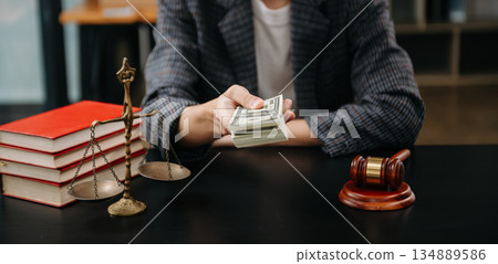 justice and law concept.passing bribe money in the envelop at lawyer office. businessman hand taking bribe money from female justice and law concept.passing bribe money in the envelop at lawyer office. businessman hand taking bribe money from female 134889586