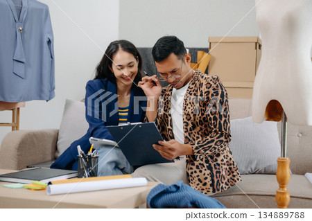Two professional young Asia cheerful lady fashion designer teamwork with casual site on table use tablet meeting discuss final design share idea in shop. Two professional young Asia cheerful lady fashion designer teamwork with casual site on table use tablet meeting discuss final design share idea in shop. 134889788