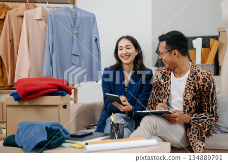 Two professional young Asia cheerful lady fashion designer teamwork with casual site on table use tablet meeting discuss final design share idea in shop. Two professional young Asia cheerful lady fashion designer teamwork with casual site on table use tablet meeting discuss final design share idea in shop. 134889791