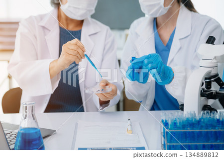 Scientist team meeting and writing analysis results in the laboratory study and analyze scientific sample Scientist team meeting and writing analysis results in the laboratory study and analyze scientific sample 134889812